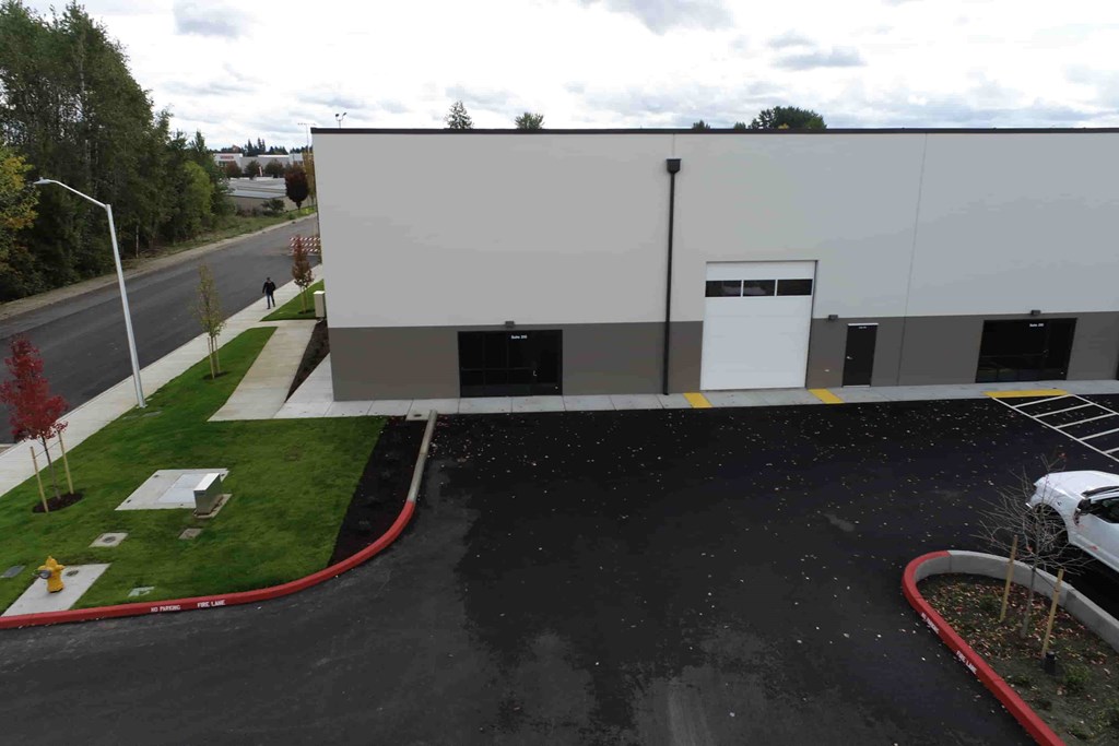 a large building with a road and grass next to it