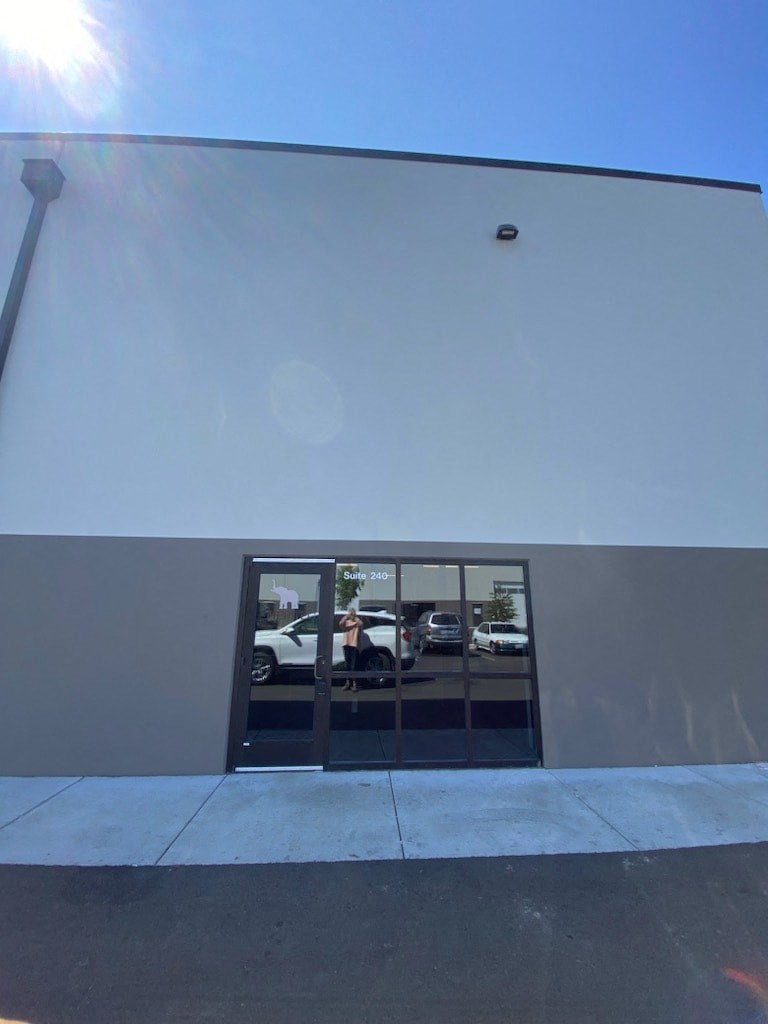 the front door of a building with a reflection of cars in the window