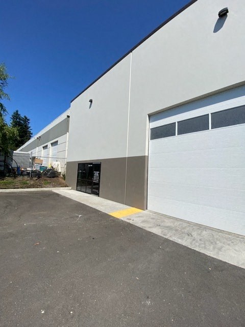 a large industrial building with a white garage door