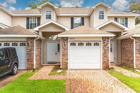 a house with two garage doors and a car parked in front of it