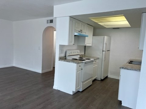 A kitchen with white appliances and a marble countertop.