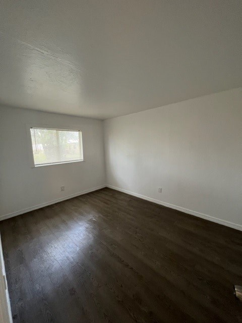 A room with a window and wooden flooring.