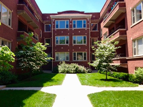 A red brick building with a white pathway in front.