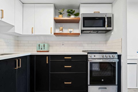a kitchen with black and white cabinets and a stove