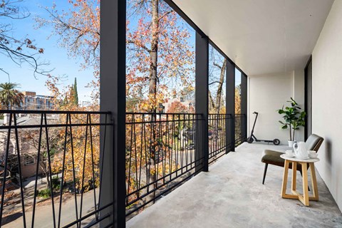 a balcony with a table and chairs and a large window