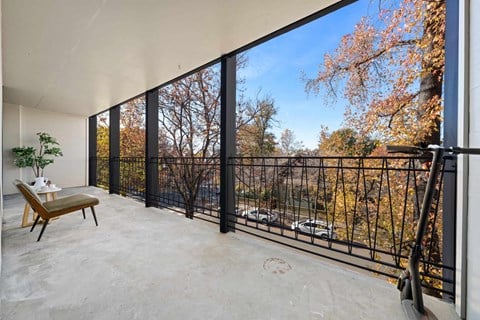 the living room has a balcony overlooking the trees