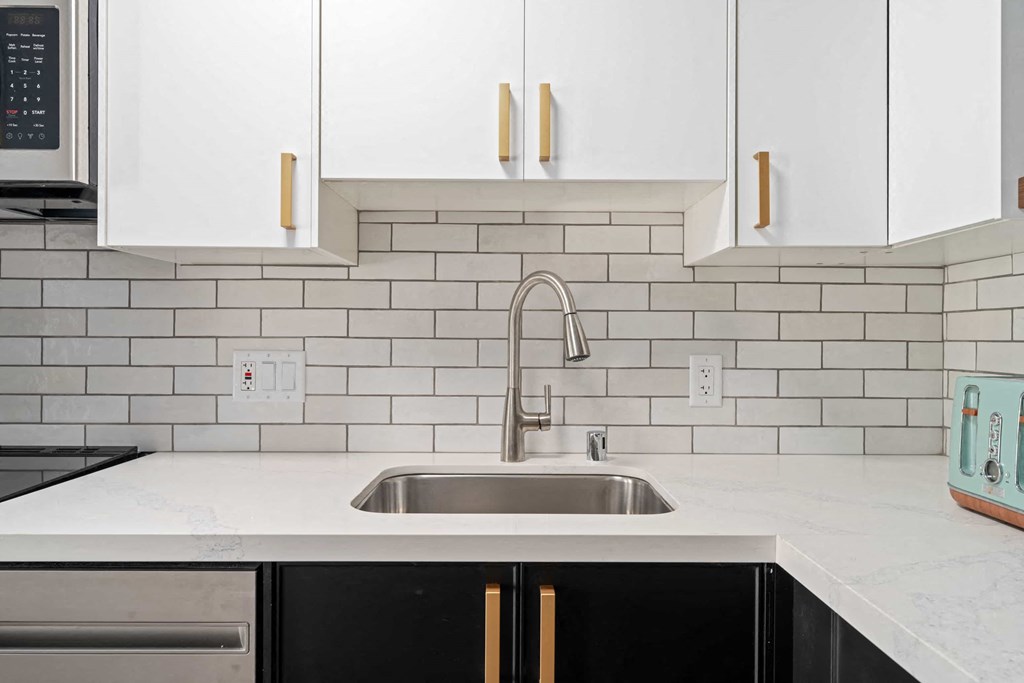 a clean kitchen with white cabinets and a sink