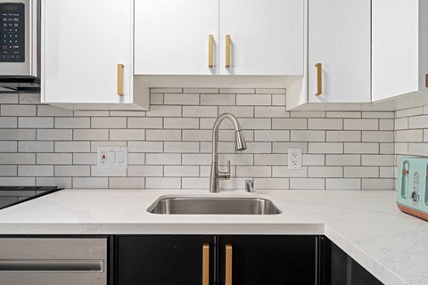 a clean kitchen with white cabinets and a sink