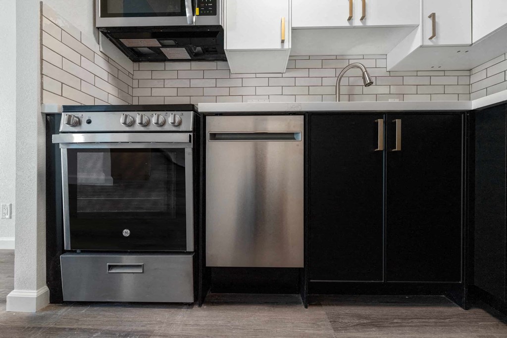 a kitchen with stainless steel appliances and black cabinets