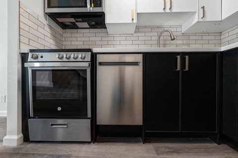 a kitchen with stainless steel appliances and black cabinets