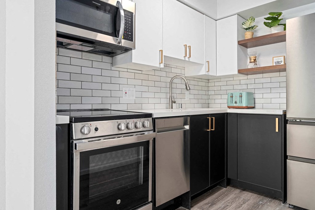 a kitchen with stainless steel appliances and black and white cabinets