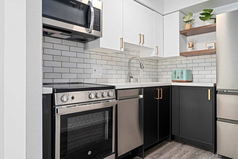 a kitchen with stainless steel appliances and black and white cabinets