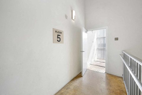 a hallway with a door to a room 5 and a sign on the wall