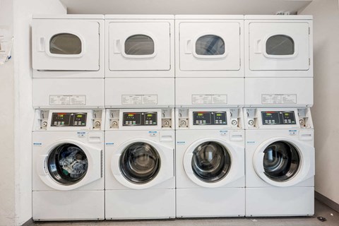 a row of white washing machines in a laundry room