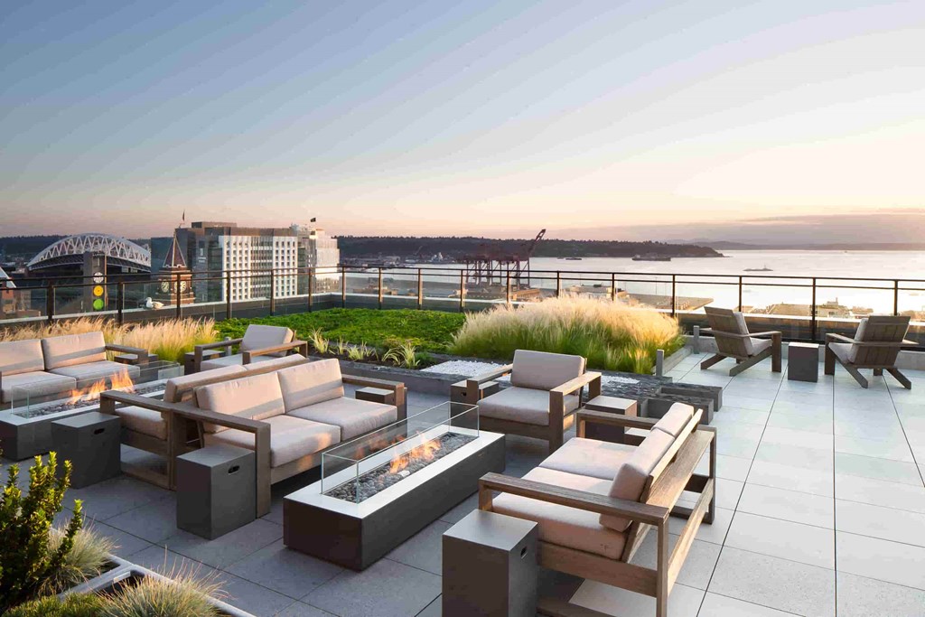 a rendering of a rooftop terrace with furniture and a fire pit