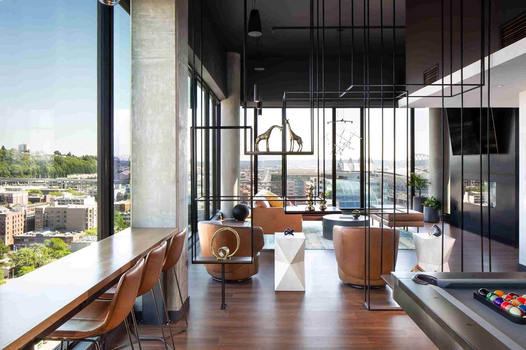 a room with a view of the city and a table with chairs