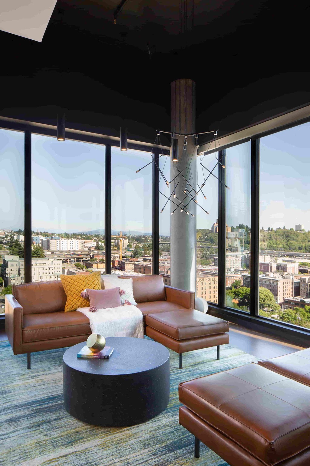 a living room in a skyscraper with couches and a table