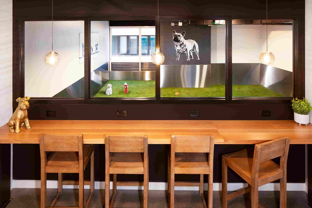 a dining room with a wooden table and chairs and a dog on a tv