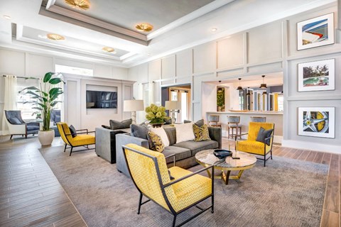 A living room with a yellow chair and grey couch.