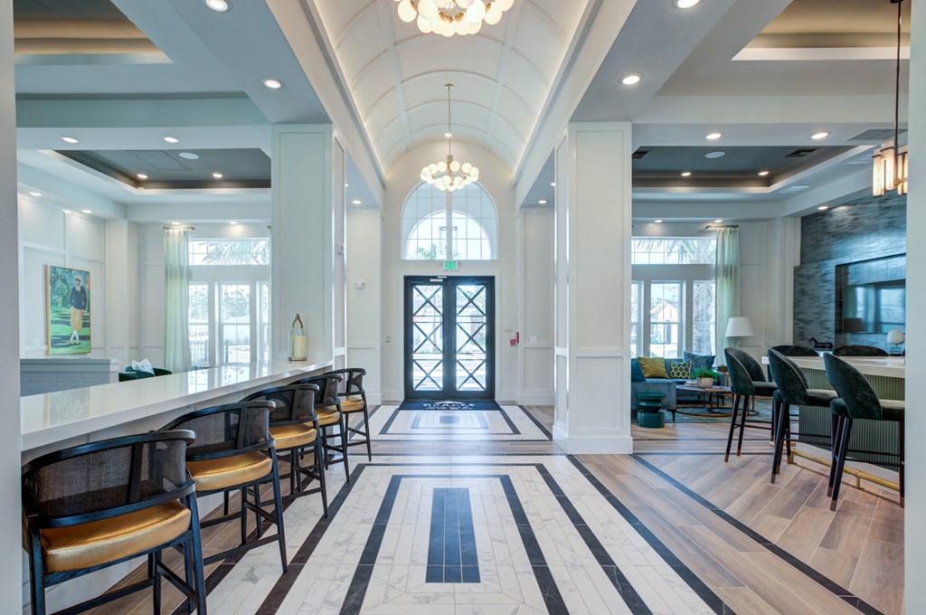the lobby of a hotel with a bar and chairs