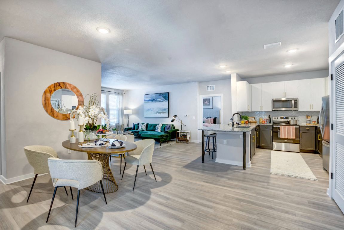a living room and kitchen with a table and chairs