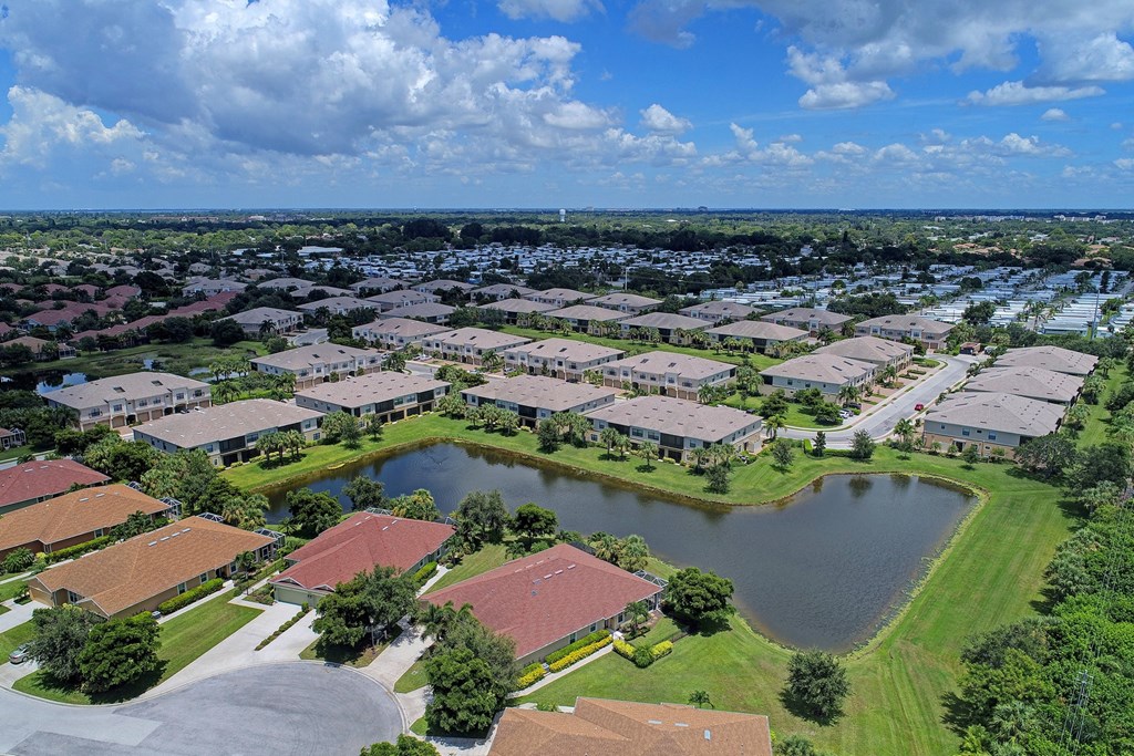 an aerial view of a community with a pond and houses