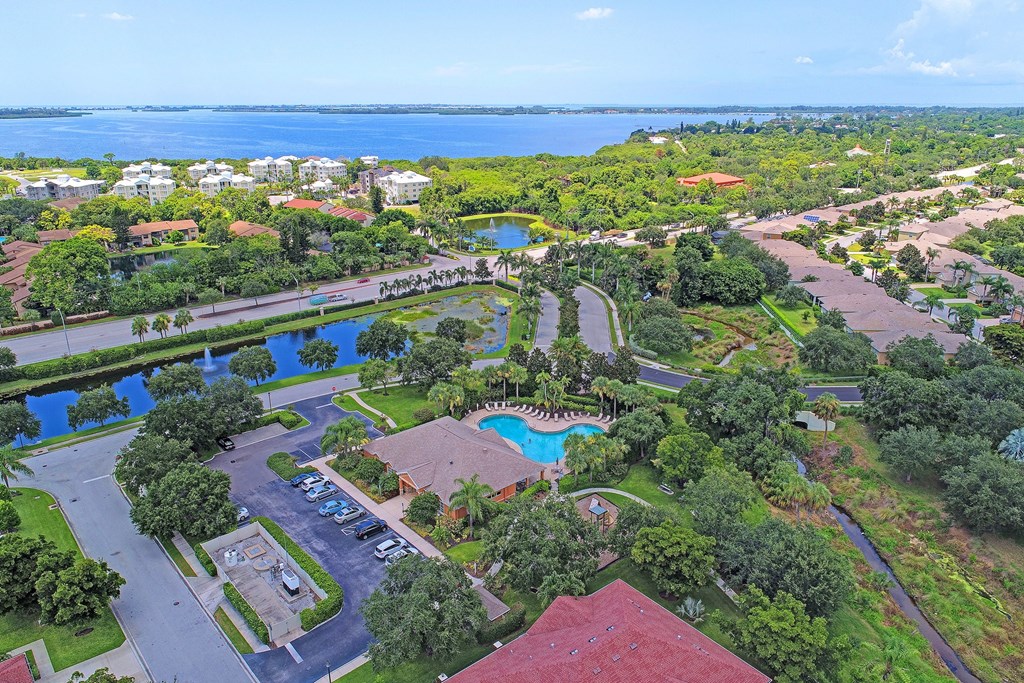 an aerial view of the resort with a pool and a lake