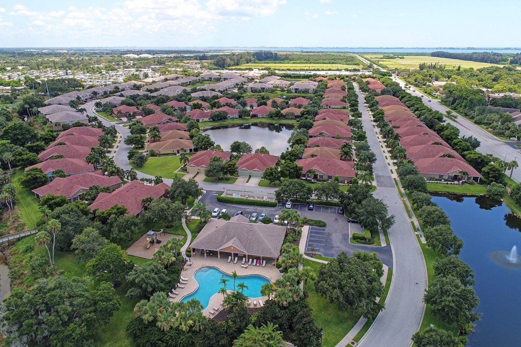 an aerial view of a resort community with a pool and a lake
