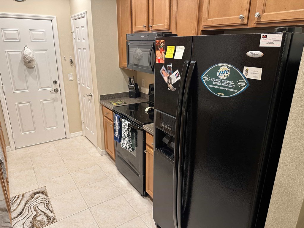 a kitchen with a refrigerator and a stove and a door