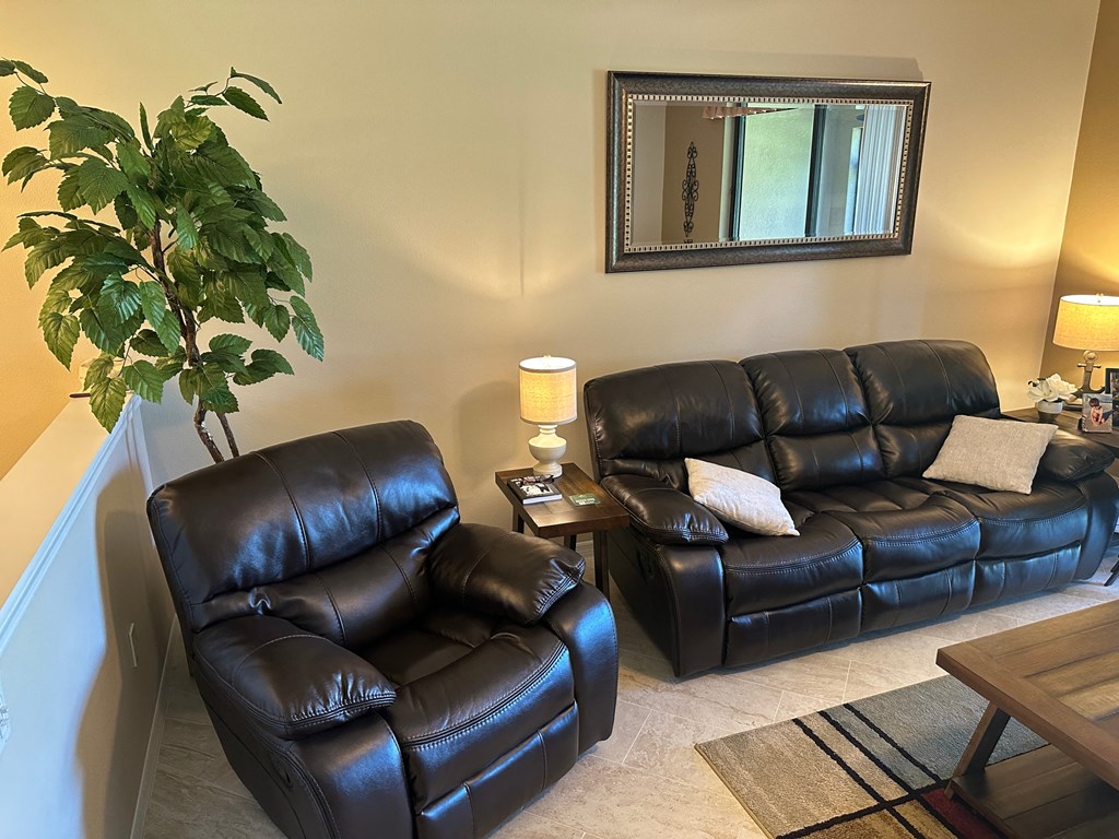 a living room with leather furniture and a mirror