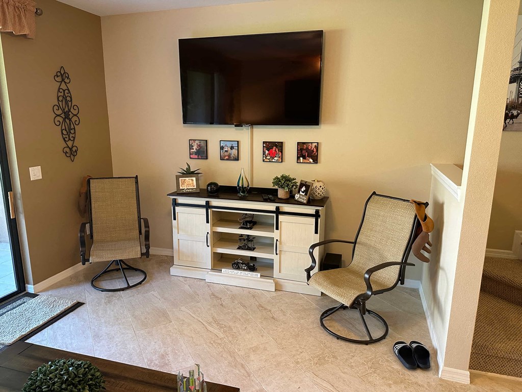 a living room with two chairs and a tv
