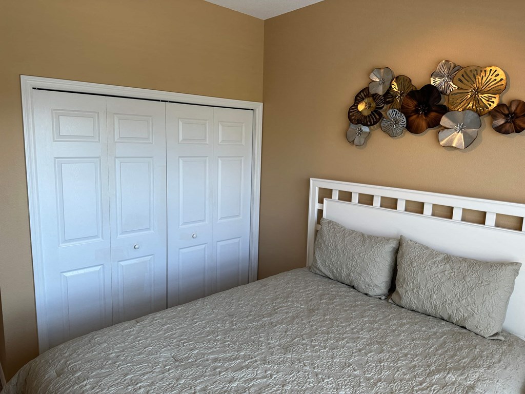 a bedroom with a bed and two closet doors