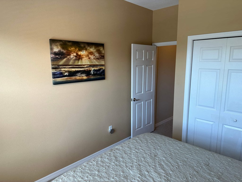 a bedroom with a large bed and a painting on the wall