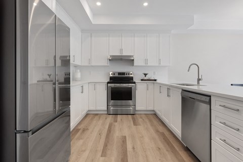 a renovated kitchen with white cabinets and stainless steel appliances