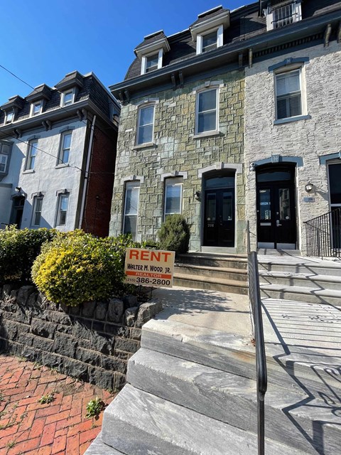 a building with a rent sign in front of it