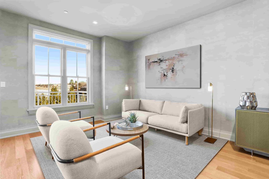 A living room with a couch, chairs, and a painting on the wall.