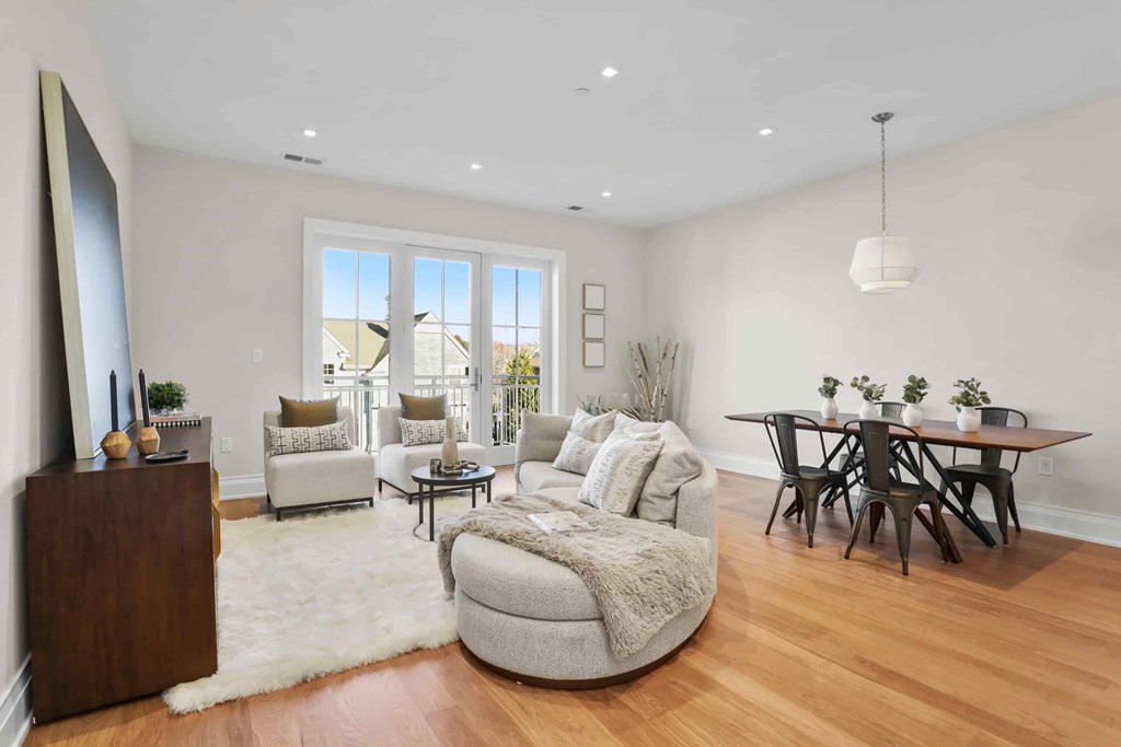 A modern living room with a white rug and a wooden floor.