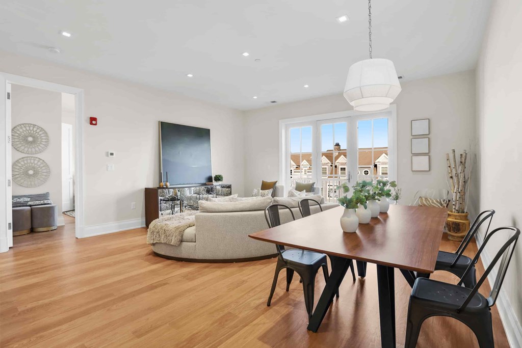 A modern dining room with a wooden table and chairs.