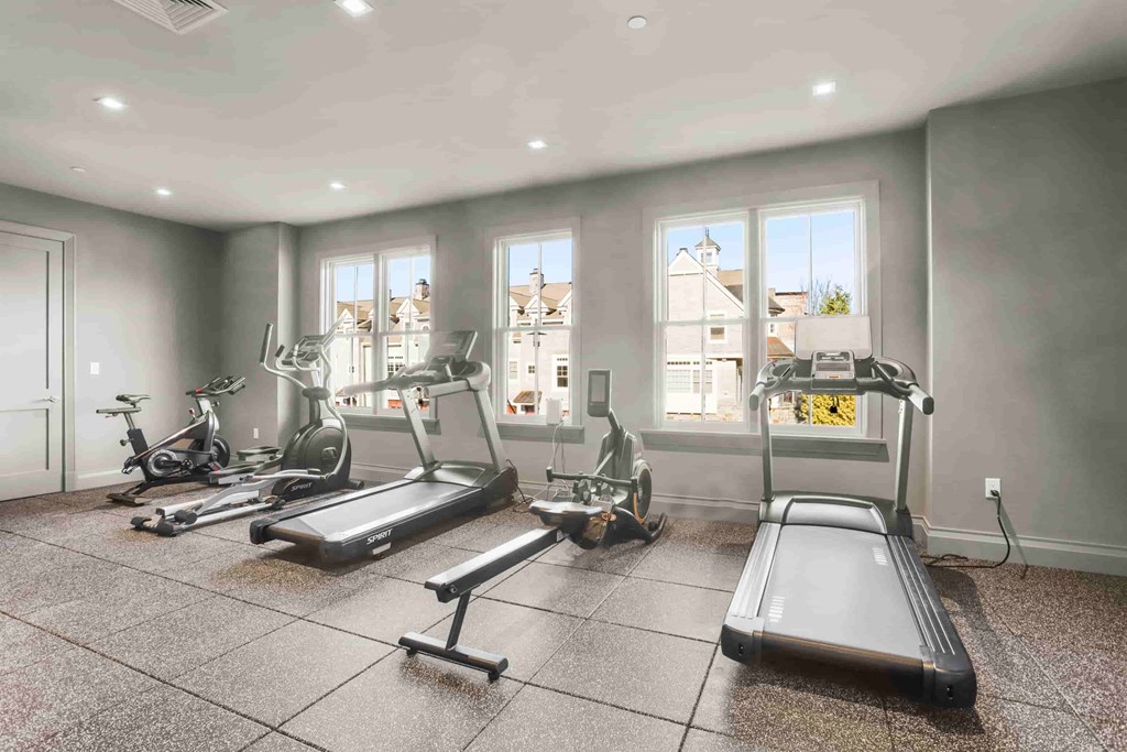 A spacious home gym with treadmills, elliptical machines, and stationary bikes.