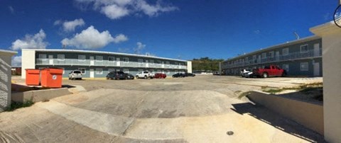 an empty parking lot with cars in front of a building