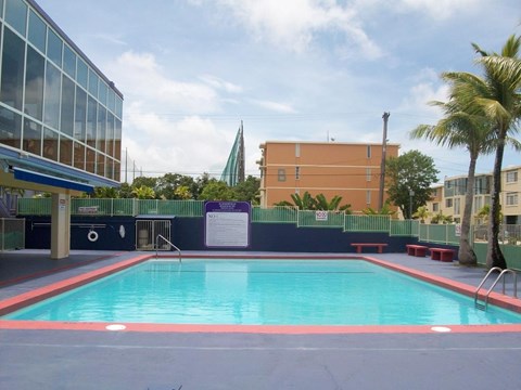 A swimming pool with a red border and a sign in the background.