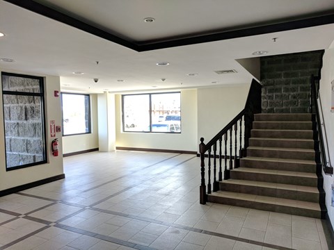 A spacious interior with a staircase and a fire extinguisher on the wall.