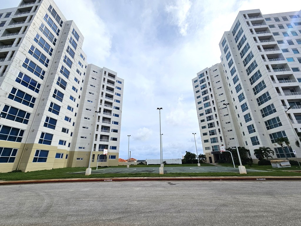 A parking lot in front of a large building.