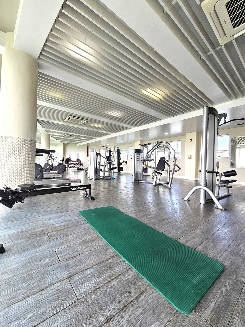 A gym with a green mat in the foreground.