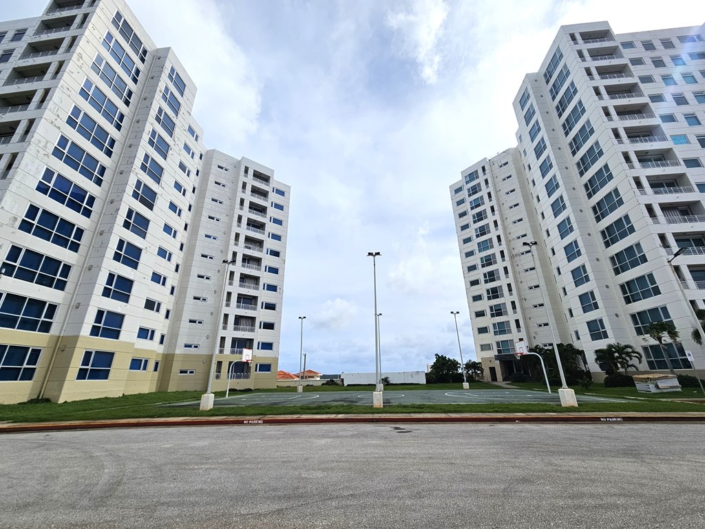A parking lot in front of a large building.