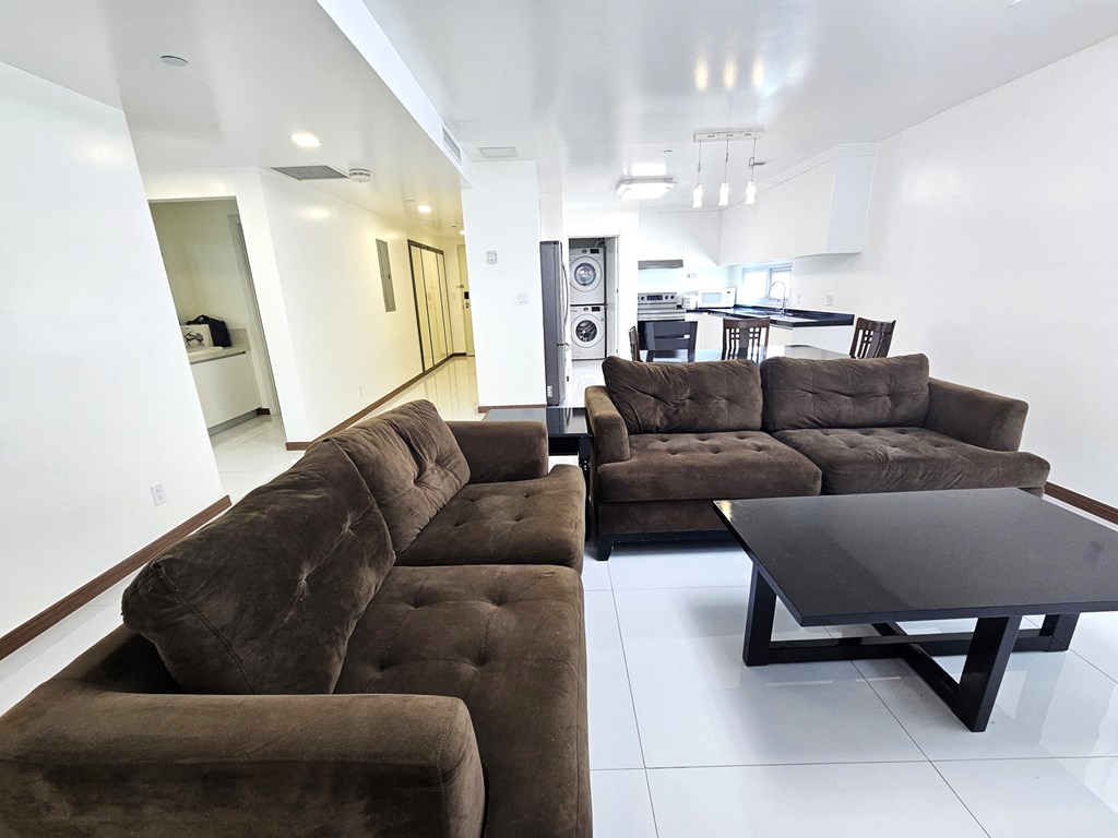 A brown couch in a white room with a black coffee table.