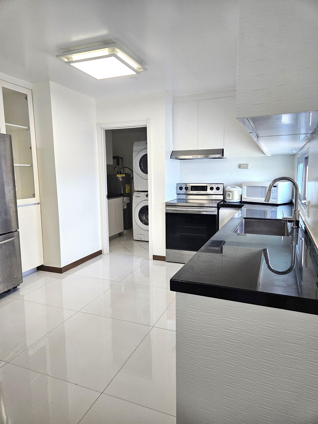 A modern kitchen with a black countertop and white appliances.