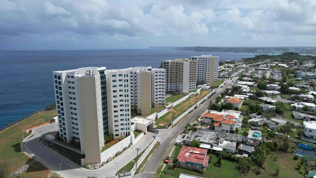 A coastal city with apartment buildings and a road.