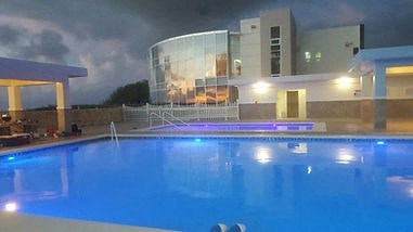a large swimming pool in front of a large building