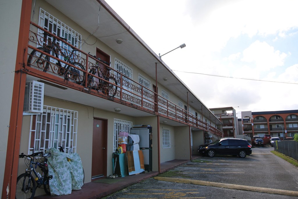 the side of a building with bikes and a parking lot
